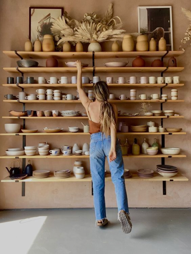 Girl in a studio reaching for a shelf